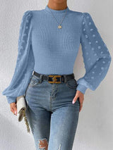 a woman wearing a blue top and ripped jeans