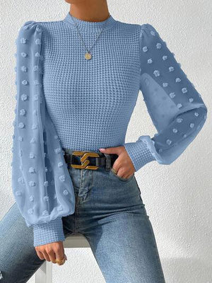 a woman wearing a blue sweater and jeans