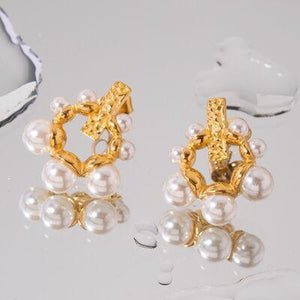 a pair of gold and pearl earrings