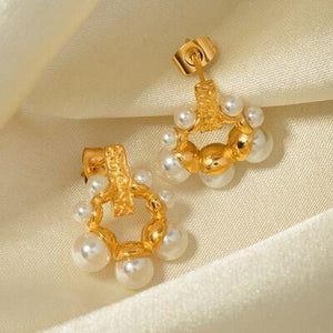 a pair of gold and pearl earrings