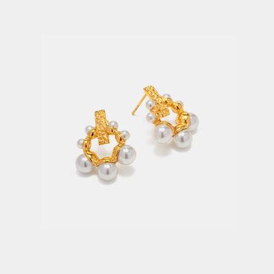 a pair of gold and pearl earrings