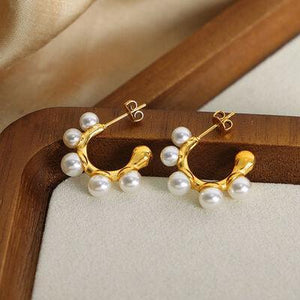 a pair of gold and white pearl earrings