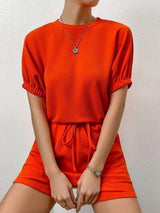 a woman in an orange dress posing for a picture