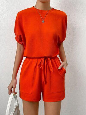 a woman in an orange top and shorts