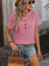 a woman wearing a pink shirt and denim shorts