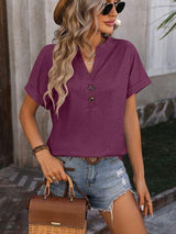 a woman wearing a purple shirt and denim shorts