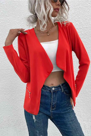 a woman wearing a red jacket and jeans