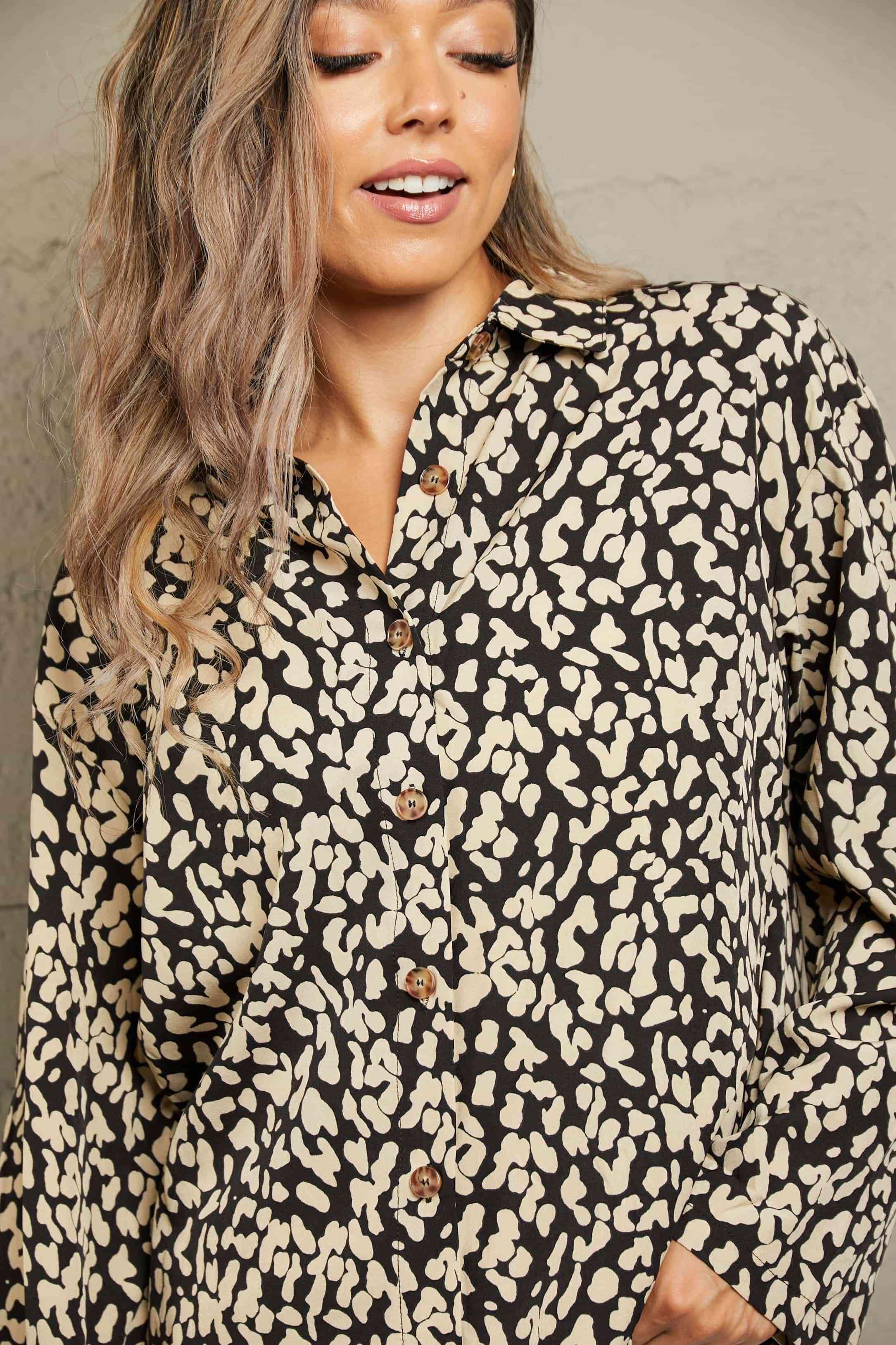 a woman wearing a black and white leopard print shirt