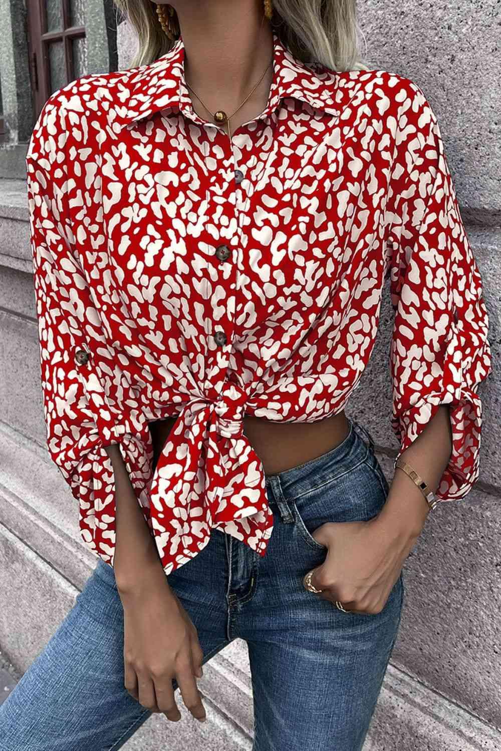 a woman wearing a red and white shirt and jeans