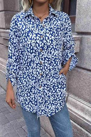 a woman standing in front of a building wearing a blue and white shirt