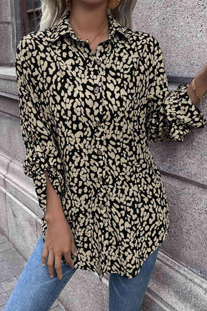 a woman standing next to a wall wearing a black and gold shirt