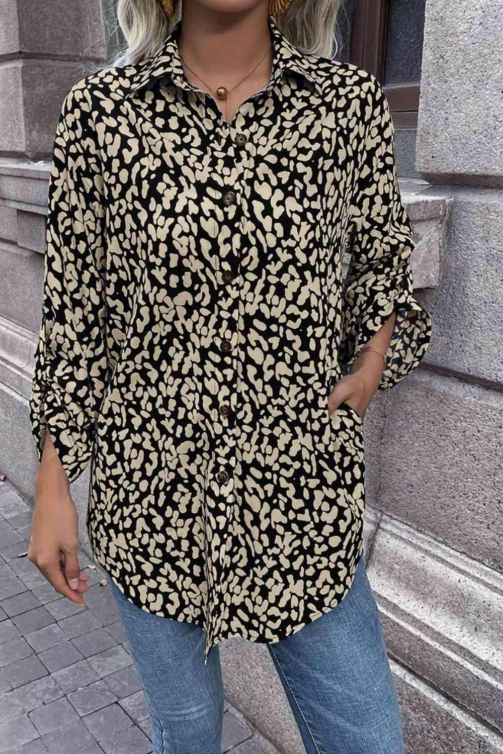 a woman standing on a sidewalk wearing a black and gold shirt