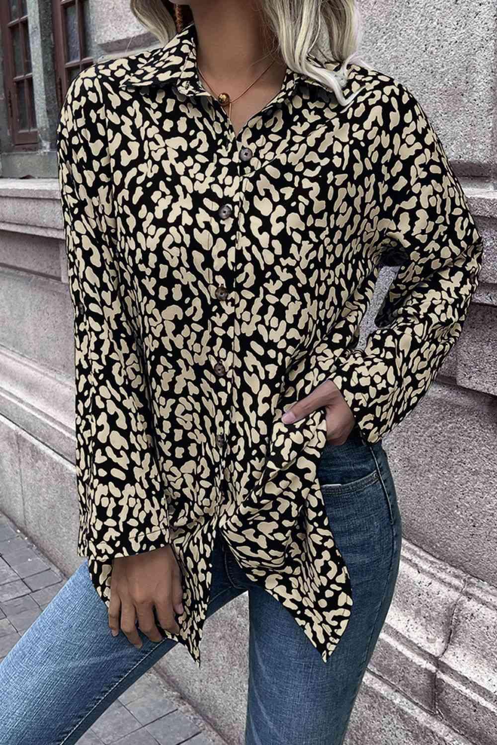 a woman wearing a leopard print shirt and jeans