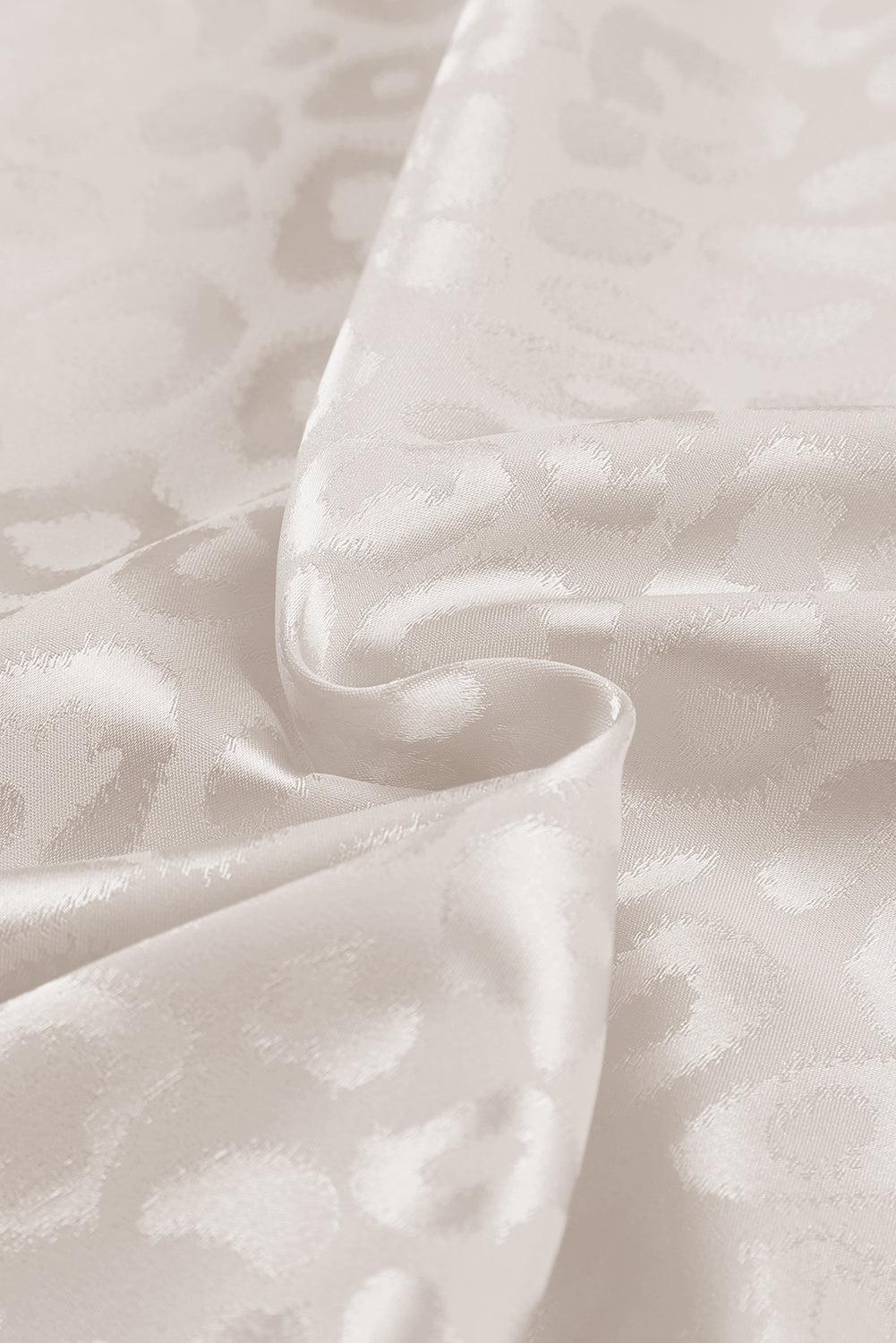 a close up of a white fabric with a flower pattern