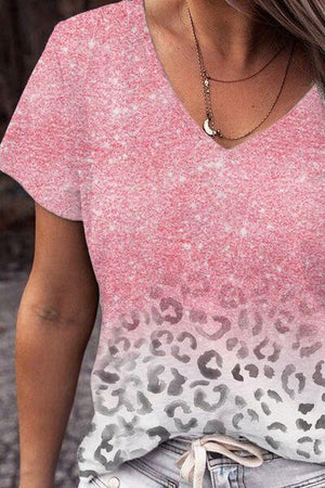 a woman wearing a pink and white t - shirt with a leopard print