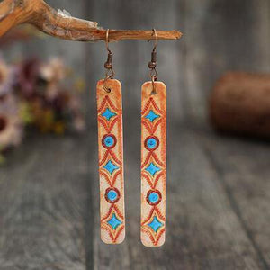 a pair of earrings hanging from a branch