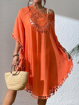 a woman in an orange dress holding a straw bag
