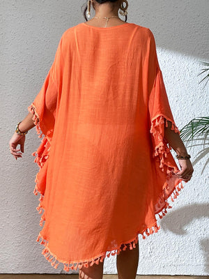 a woman in an orange dress standing on a wooden floor