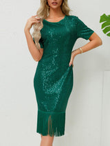 a woman wearing a green sequin dress