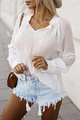 a woman wearing a white shirt and denim shorts