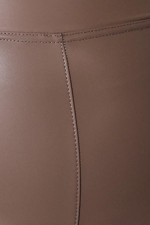 a close up of a woman's leg wearing a pair of brown leather pants