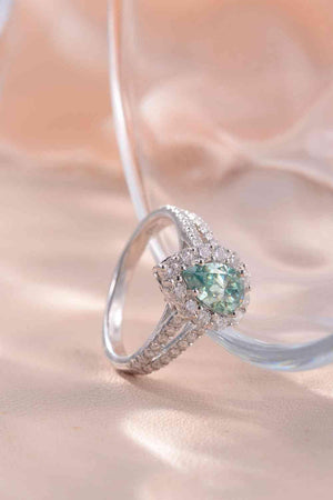 a ring with a green stone surrounded by diamonds