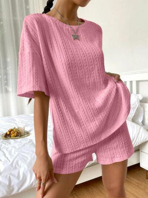 a woman wearing a pink sweater and shorts