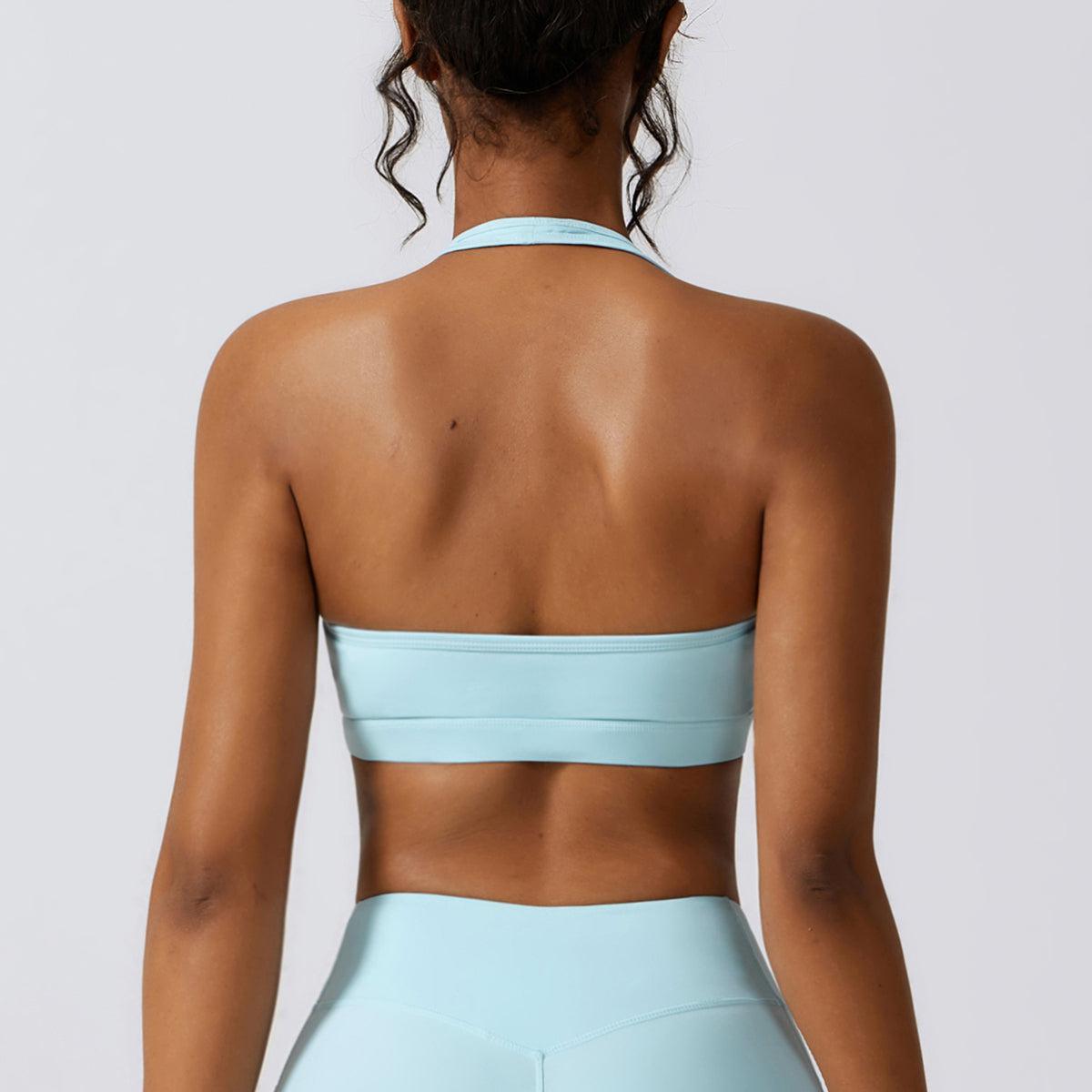 the back of a woman wearing a light blue sports bra
