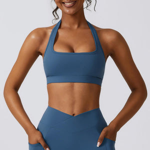 a woman in a blue sports bra top with her hands on her hips