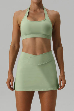 a woman in a green sports bra top and skirt