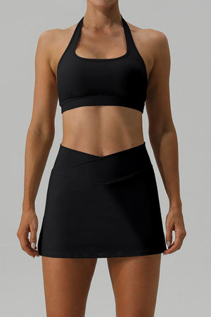 a woman in a black sports bra top and skirt
