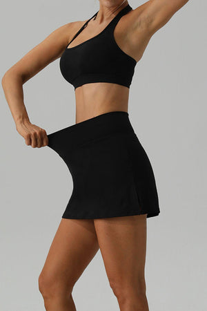 a woman in a black sports bra top and a black skirt