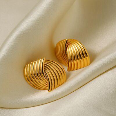 a pair of gold earrings sitting on a white cloth