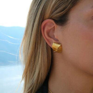 a close up of a person wearing a pair of earrings