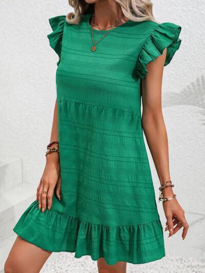 a woman in a green dress posing for a picture