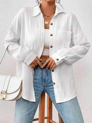 a woman standing on a stool wearing a white shirt and jeans