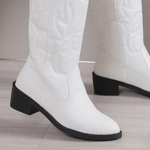 a close up of a pair of white cowboy boots