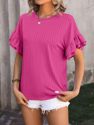 a woman wearing a pink top and white shorts