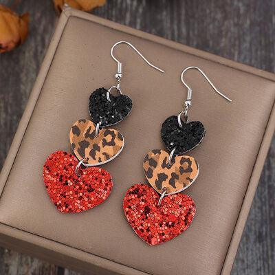 a pair of heart shaped earrings sitting on top of a box