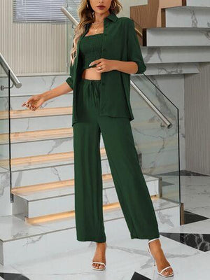 a woman standing in front of stairs wearing a green outfit