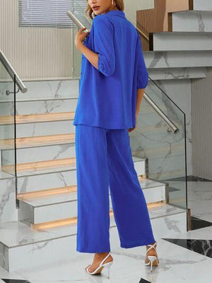 a woman in a blue outfit standing in front of a staircase