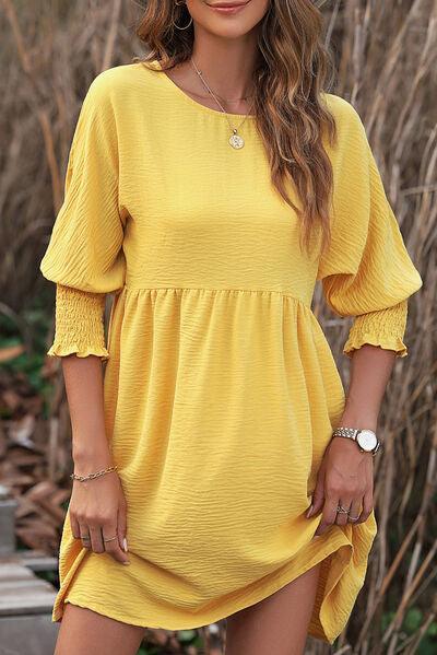 a woman in a yellow dress posing for a picture