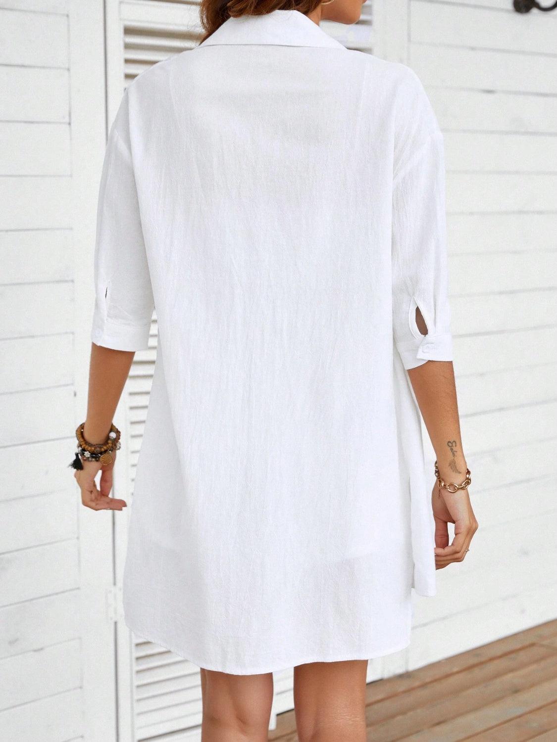 a woman wearing a white shirt dress and sandals