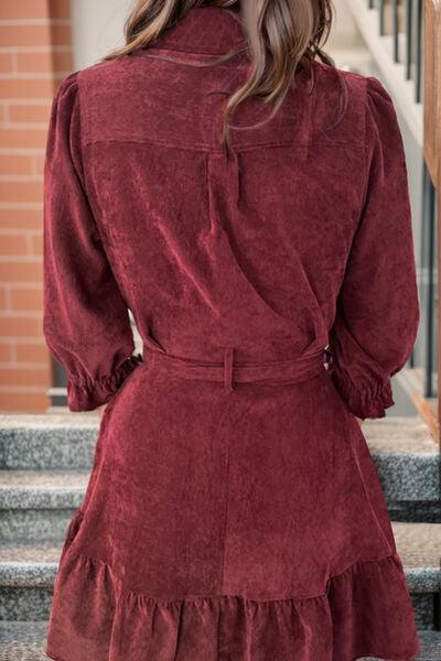 a woman in a red dress standing on some steps