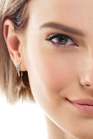 a close up of a person wearing a pair of earrings