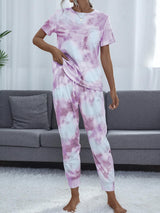 a woman in a pink and white tie dye pajamas