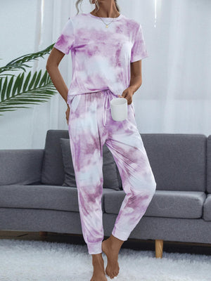 a woman standing in a living room wearing a purple tie dye outfit