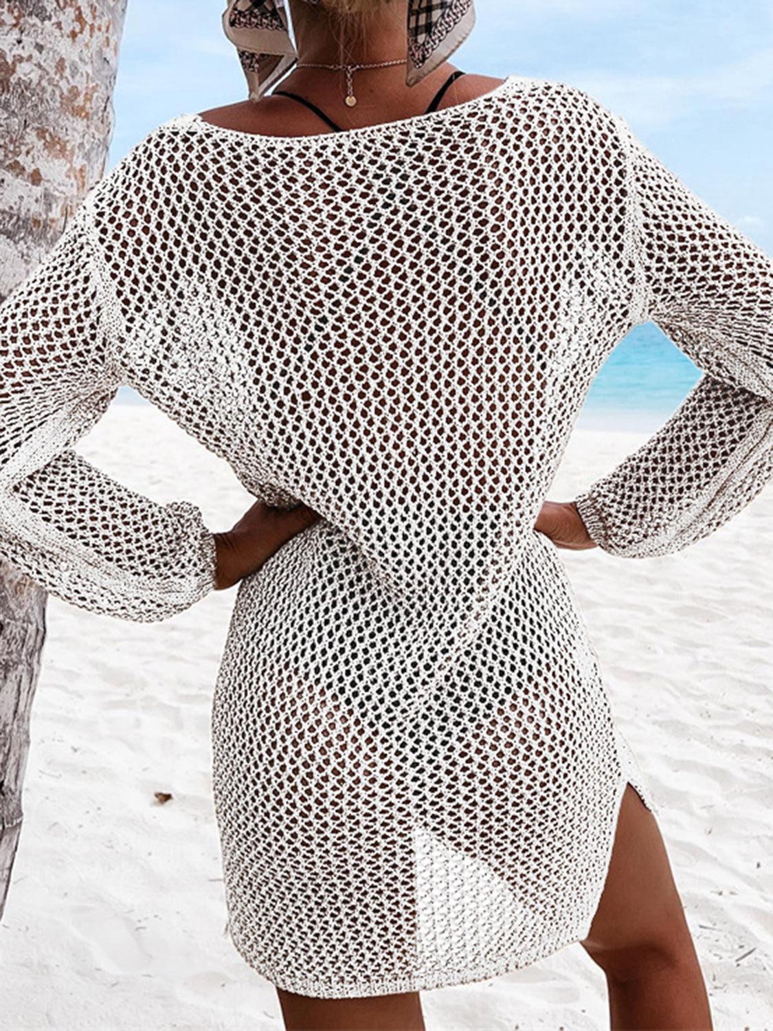 a woman standing on a beach next to a tree