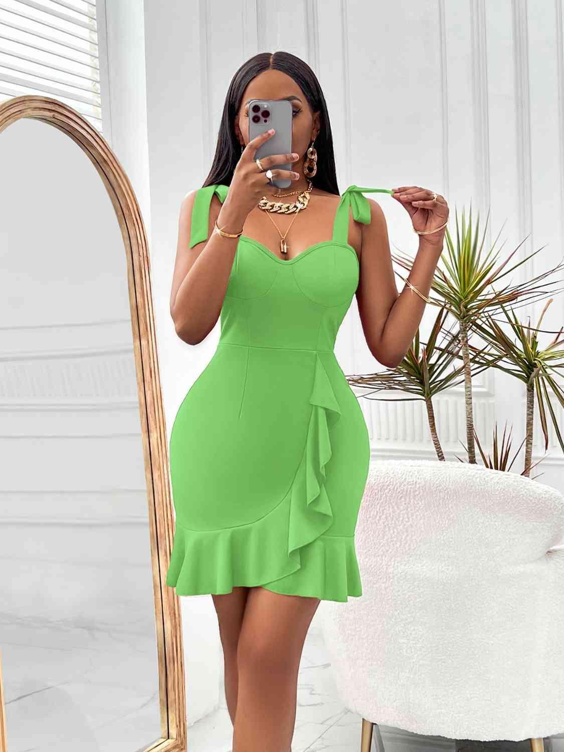 a woman taking a selfie in a green dress