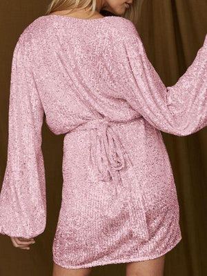 a woman wearing a pink sequin dress